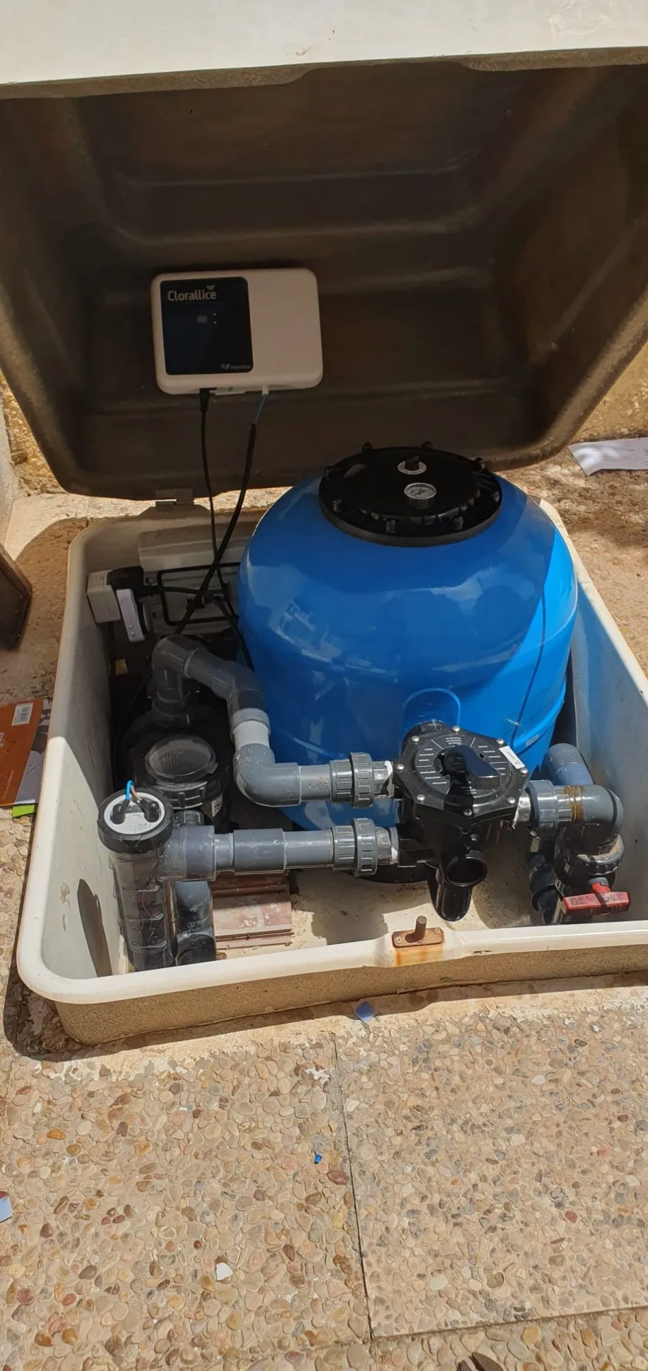 Caseta enterrada de una piscina con filtro azul, bomba, válvula selectora y clorador salino