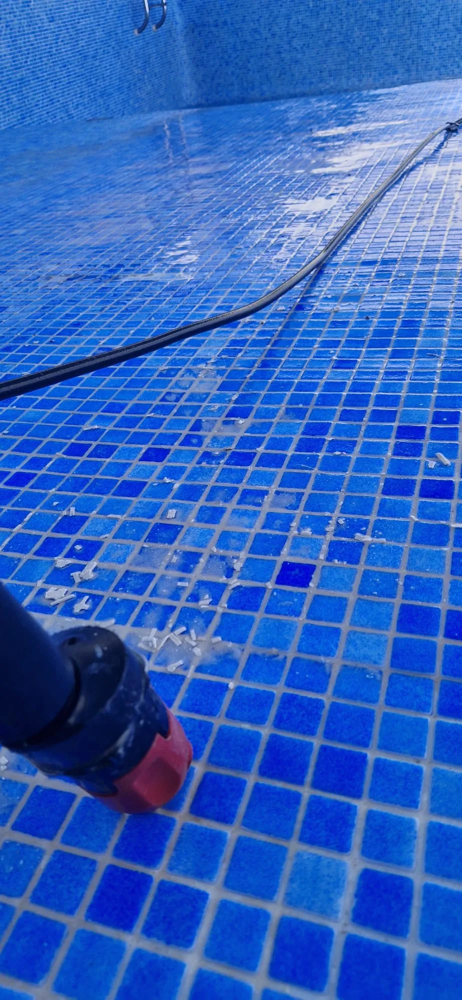 Limpieza de la junta antigua del gresite azul con agua a presión