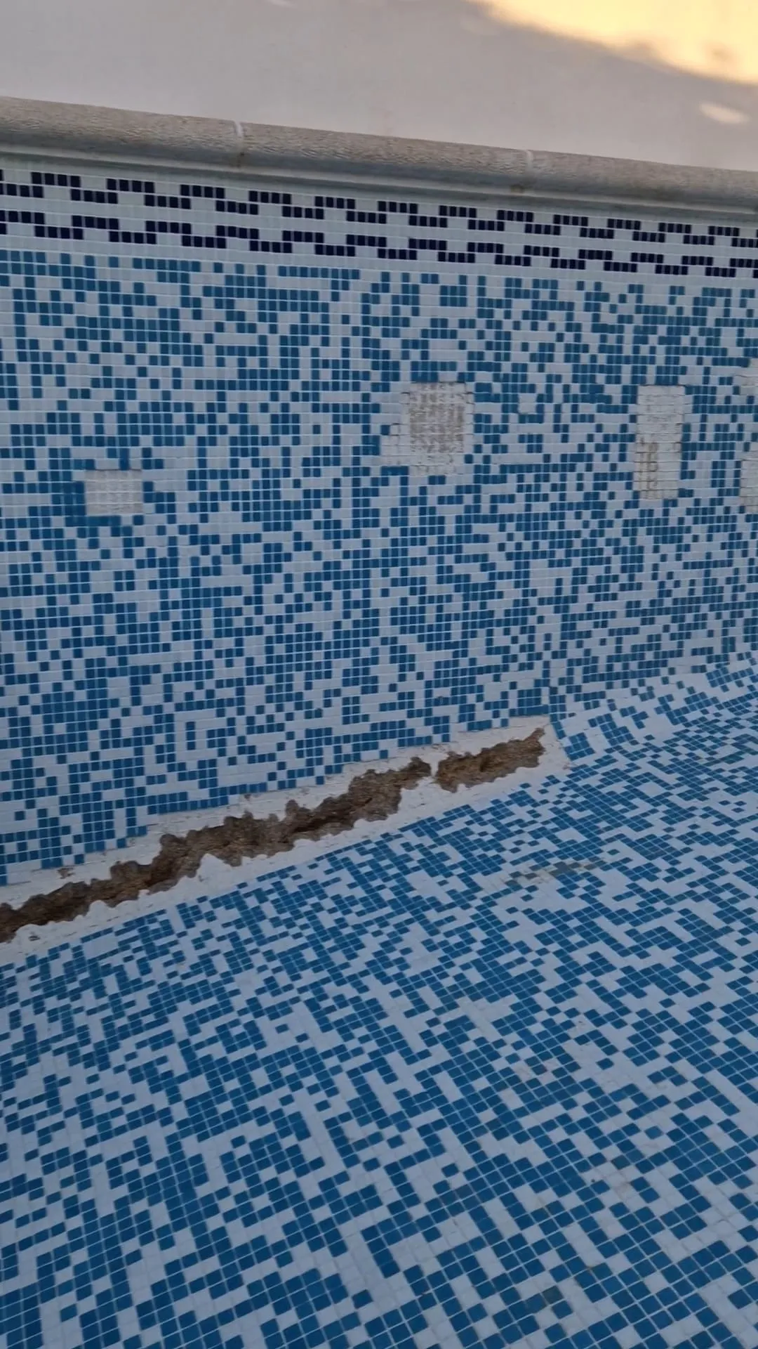 Pared de gresite con una franja abierta para llegar a la tubería durante la reparación de una fuga